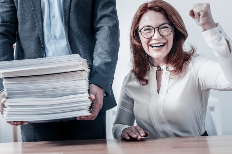 Radiant woman getting excited after checking pile of document Radiant woman getting excited after checking pile of document